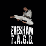 Jake Flying Sidekick, Black belt in white suit Flying over Evesham TAGB sign